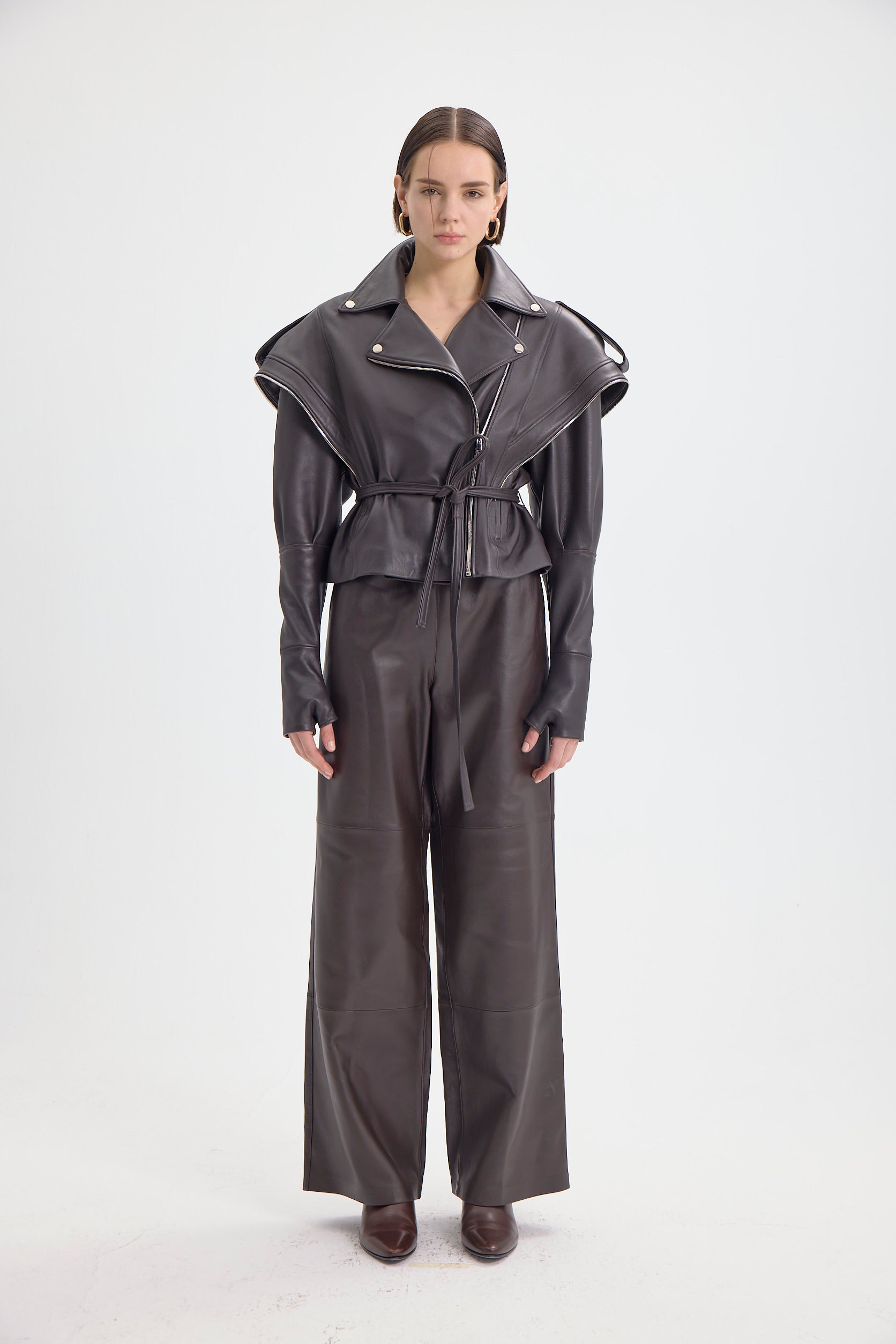 Front view of the DREJANI 'Sogno di Cacao' dark brown leather jacket featuring zip details and belted waist.